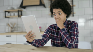 Is Angela Brown a Con Artist, Shocked Woman Looks at Tablet